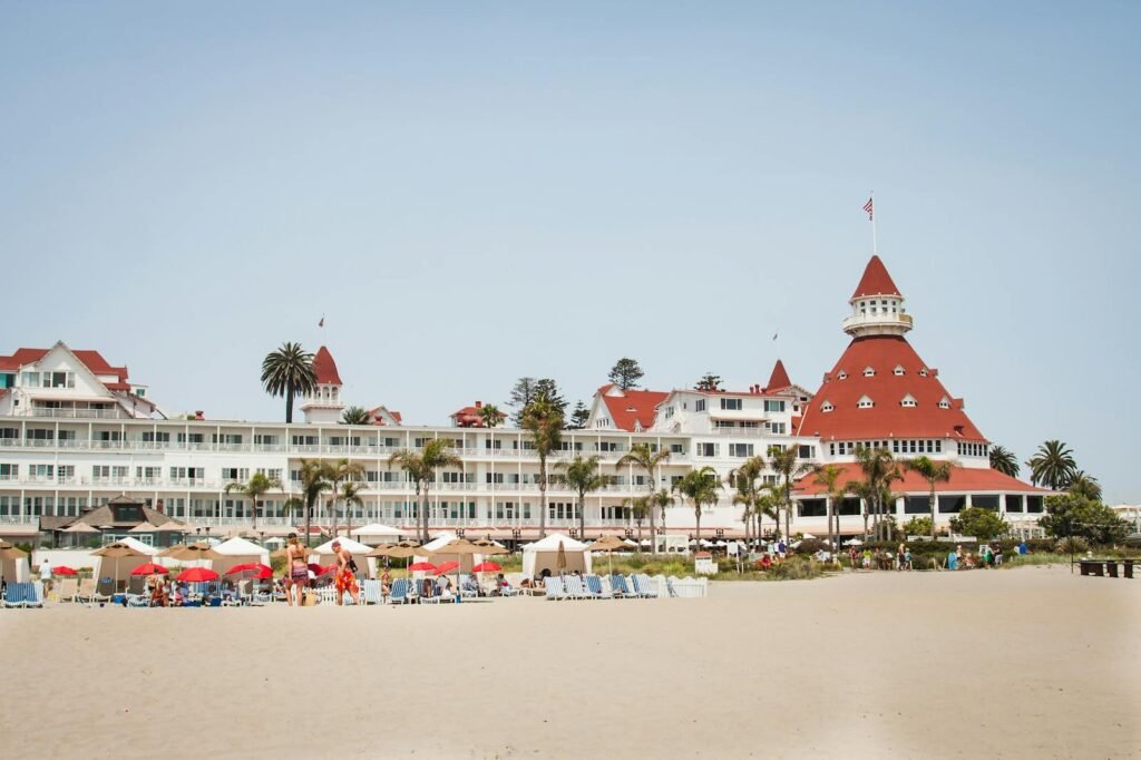 Historic Hotel del Coronado with vibrant beach scene, perfect summer travel destination.