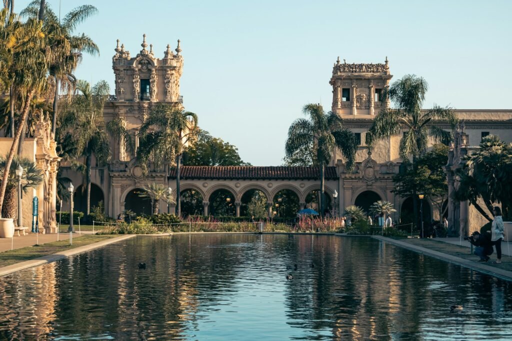 a pond in front of a building with a clock tower in the background